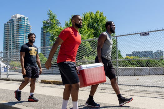 Three men casually walking outdoors holding a cooler, enjoying a sunny day.